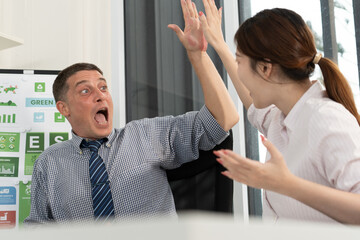 A diverse business team analyzing environmental charts and graphs in a collaborative meeting to create sustainable strategies in a modern office.