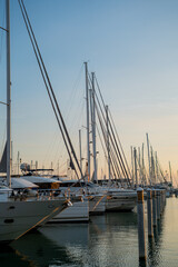 Obraz premium Large parking lot of white yachts in the bay of a French city at sunset. Summer seascape.