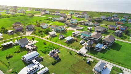 Long sandy shoreline of Beach Boyt in Port Bolivar, Texas with dense RVs parked beside colorful...