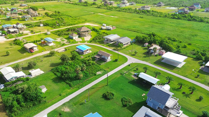 Coastal life near Beach Boyt in Port Bolivar, Texas, relaxed, seaside atmosphere and elevated on stilts homes built to handle Gulf conditions, response to coastal flood risks and storm surge