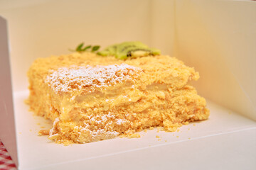 Delicious creamy layered pastry with kiwi garnish in white box