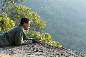 a young man lies flat on a mountaintop.