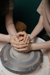 Potter shaping a ceramic artwork on a wheel. Hands in clay. Artistic pottery workshop