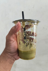 Hand Holding Partially Drunk Avocado Juice