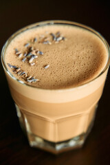 Creamy lavender latte with frothy layer in clear glass cup