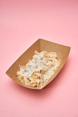 Kataifi nest with creamy sauce on eco-friendly tray against pink backdrop