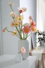 Beautiful poppy flowers on white table indoors