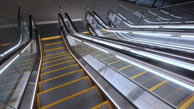Multiple contemporary escalators with bright lighting, symbolizing movement and urban transit in a busy Tokyo setting.