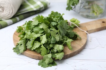Fresh aromatic cilantro on white table, closeup
