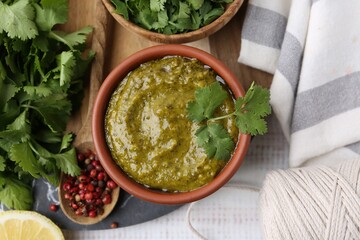 Tasty sauce with cilantro and other ingredients on white wooden table, top view