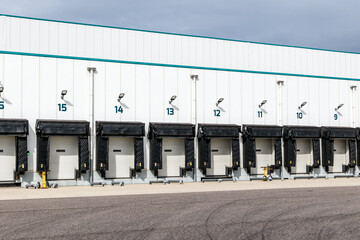 Modern industrial logistics warehouse row of closed loading docks with metal shutter doors for...