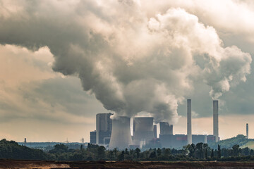 Emissions rising from a power plant chimney, contributing to air pollution and environmental impact