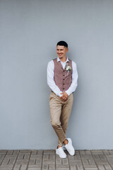 portrait of the groom in a gray suit and an orange vest
