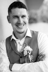 portrait of the groom in a gray suit and an orange vest