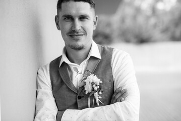 portrait of the groom in a gray suit and an orange vest