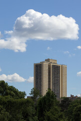 view of tall apartment building in queens with big puffy white clouds in the background (co-op real estate condo cooperative apartments public housing) balcony balconies pre-war old house home forest
