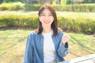 公園でガッツポーズをする日本人女性