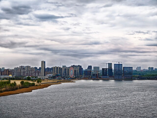 Fototapeta premium Cityscape of Kazan along the River with Cloudy Sky in the Background