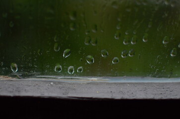 Rain drops on window, blurred green background