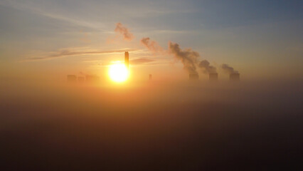 Aerial view of Drax Power Station at sunrise, with thick fog obscuring the lower structures and smoke plumes rising