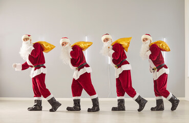 Happy New Year cute group carrying sacks, presenting gift box, partying fun wearing Santa Claus...