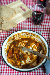 Enjoying a hearty meat stew with bread and wine