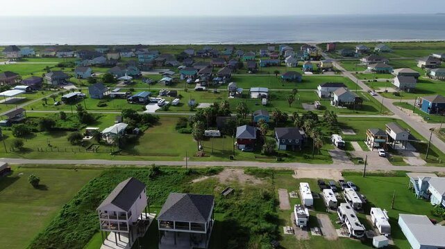 Elevated colorful beach house in oceanside neighborhood with road access to sandy shoreline. Ideal vacation rental setup beach proximity, car, UTV access, storm-safe design in Port Bolivar, Texas
