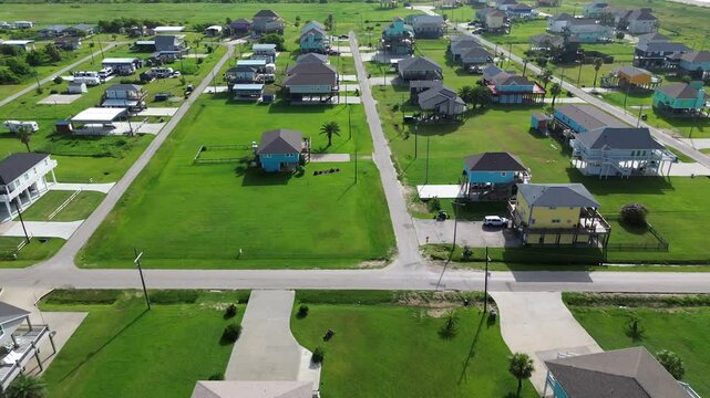 Boyt Beach in Port Bolivar, Texas with elevated vacation rental, scenic ocean views and storm-safe design. Surrounded by open green lawn, blends relaxed coastal living with real estate potential