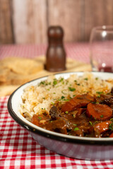 Hearty beef stew with rice on rustic table