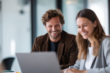 customer care personalized. Two professionals enjoying a collaborative moment over a laptop in a bright office setting.