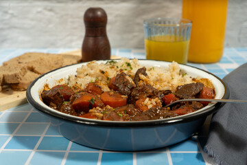 Hearty beef stew with rice and vegetables on table