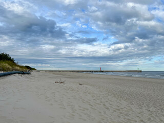 The eastern beach in Mrzezyno, Poland, with a pipe that is sometimes attached to the port dredger to drain sand from the dredging to the beach