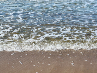 Foam on the shallow water of the Baltic Sea, Mrzezyno region, Poland, in calm weather as a background