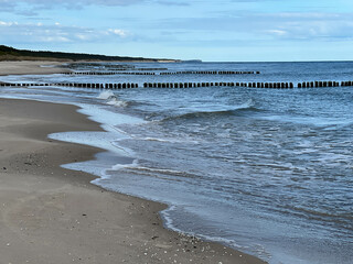 Empty Baltic beach in the Mrzezyno area in Poland with characteristic breakwaters made of pegs