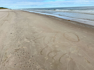 Sand on the Baltic Sea beach in Mrzezyno in Poland after being washed by a wave in close-up as a background