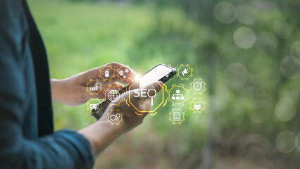 Businessman using mobile phone with SEO and digital marketing icons, symbolizing search engine...
