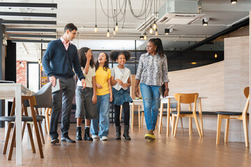 Diverse Group of Kids and Adults Walking Through a Modern Office Space, Mentors Guiding Young...