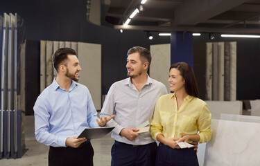 Sale manager consulting couple customers in show room, marketing, showing clients modern samples,...