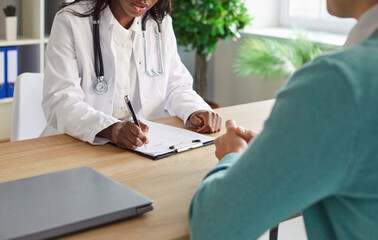 Close-up of african american doctor or nurse in clinic providing medical consultation and...