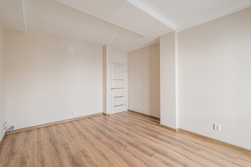 empty room features light walls, wooden floor, and a door with glass inserts. The space is bright...