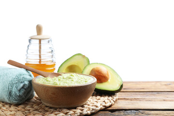 Homemade hair mask in bowl, fresh ingredients and towel on wooden table against white background....