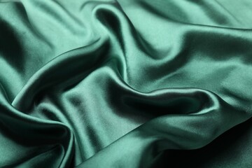 Crumpled green silk fabric as background, closeup