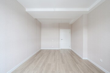 empty room with light walls, wooden floor, and a white door. Bright and minimalist style