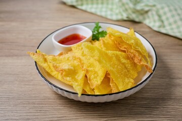 Deep Fried Wontons in white plate on wooden background	
