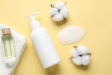 Flat lay composition with bottle of liquid soap and cotton flowers on yellow background