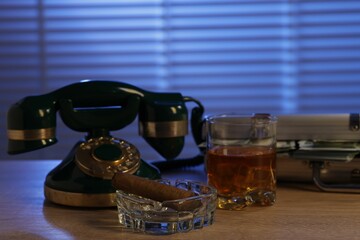 Mafia and criminal world. Money, whiskey, cigar and telephone on wooden table indoors