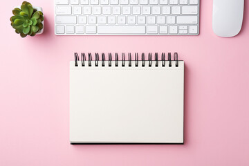 Notebook, floral decor, computer keyboard and mouse on pink background, flat lay