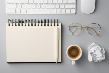 Notebook, pen, crumpled paper, coffee, computer keyboard and mouse on grey background, flat lay