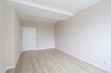 bright, empty room with light wood floors, beige walls, white trim and door. Clean and modern interior space