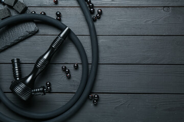 Hookah, coal and currants on black wooden table, flat lay. Space for text